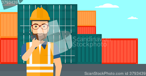 Image of Stevedore standing on cargo containers background.