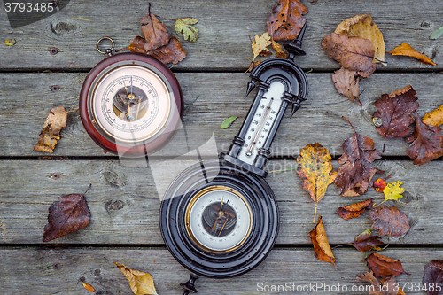 Image of Two antique barometers on wood