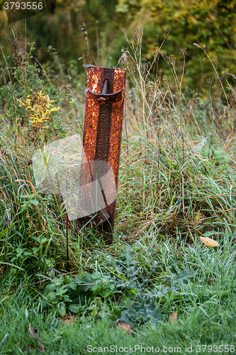 Image of Rusty metal pole on a field