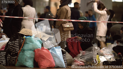 Image of Female Aid Worker Distributing Clothes at Charity Collecting Point in Copenhagen Railroad Station