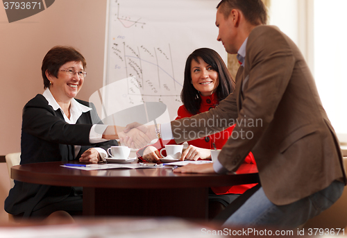 Image of Business man and woman shaking hands