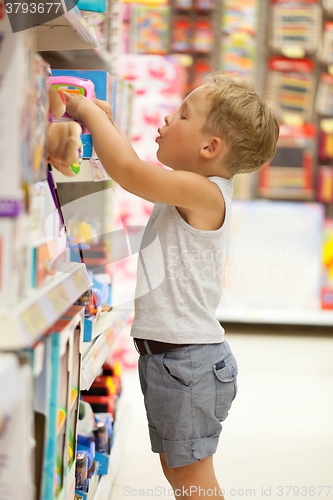 Image of Boy choosing toy in the shop