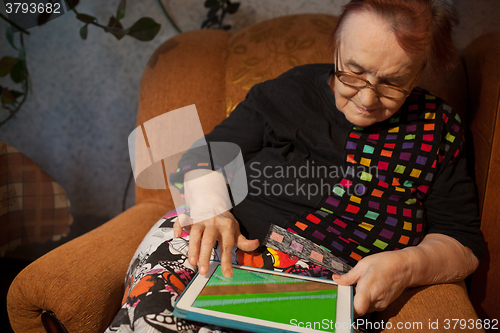 Image of Senior woman surfing the internet on a tablet