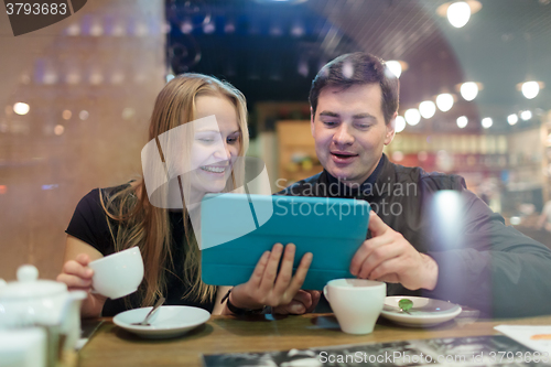 Image of Young people drinking coffee and looking on pad