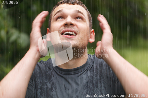 Image of Young man under the rain.