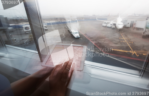 Image of Woman working with tablet PC in airport terminal