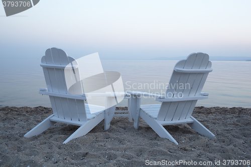 Image of Empty wooden deck chairs on a beach