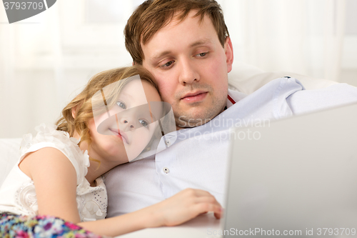 Image of Father and little daughter using laptop