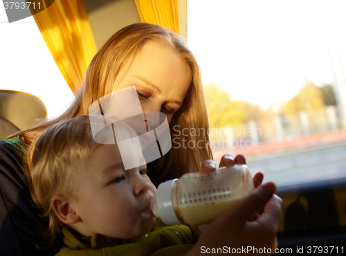 Image of Mother is feeding her kid in the bus.