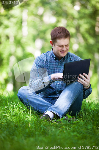 Image of Businessman working in the city park.