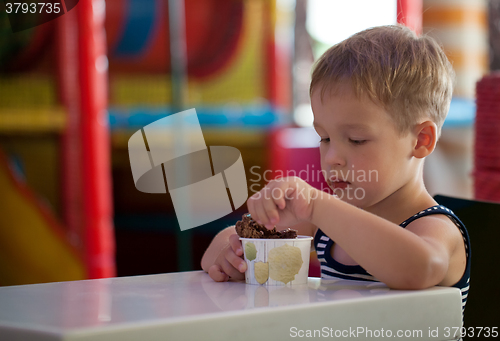 Image of Little child eating chocolate ice cream