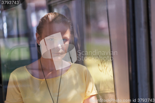 Image of Young woman in yellow rides the bus