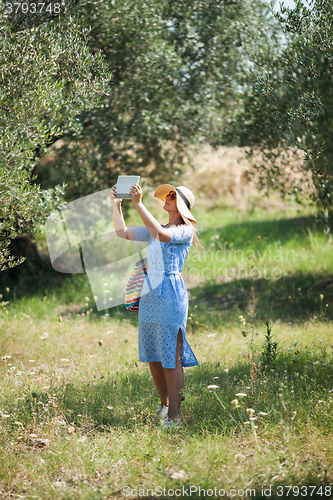 Image of Woman taking nature shots with touch pad