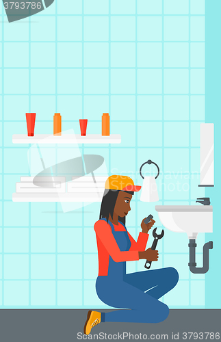 Image of Woman repairing sink.