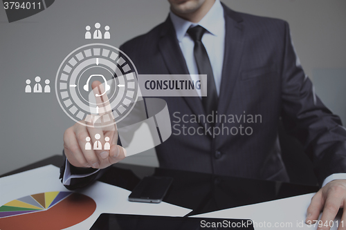 Image of Businessman pressing button on touch screen interface and select Consulting. Business, internet, technology concept.