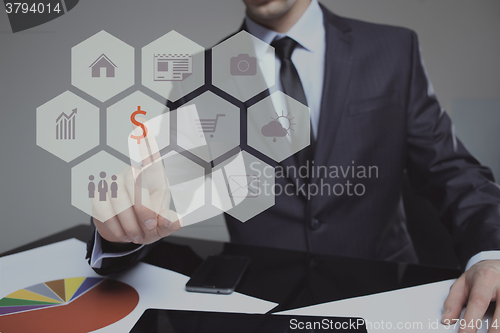 Image of Businessman presses digital interface dollar sign