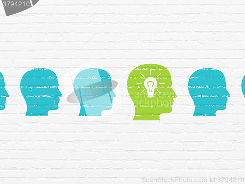 Image of Business concept: head with light bulb icon on wall background