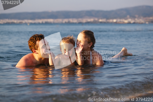 Image of Laughing little boy with his parents at the sea