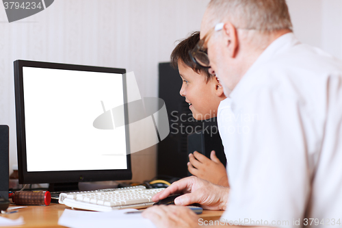 Image of Grandfather and grandson in front of the computer