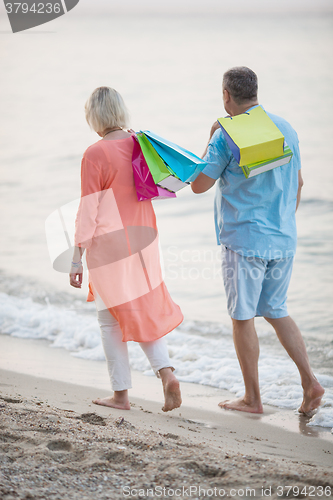 Image of Couple walking on the beach after vacation shopping