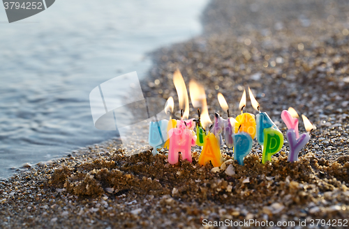 Image of Birthday candles burning on a seashore