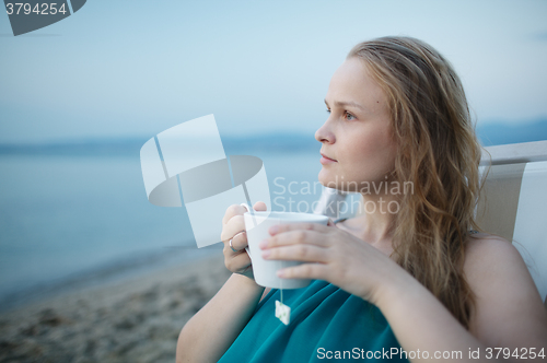 Image of Woman enjoying a cup of tea at the seaside
