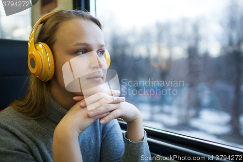 Image of Woman traveling by train with favorite music