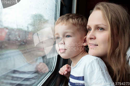 Image of Mother and son looking through a train window