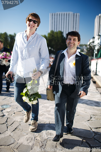 Image of Two smiling men walking down a street