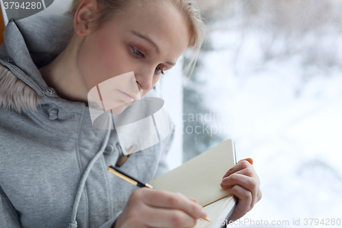 Image of Young girl writing in her journal.