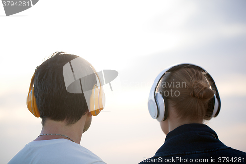 Image of Young people in headphones enjoying music outdoor