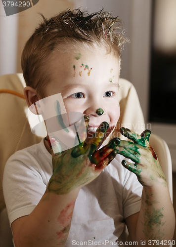 Image of Excited little boy playing with finger paints