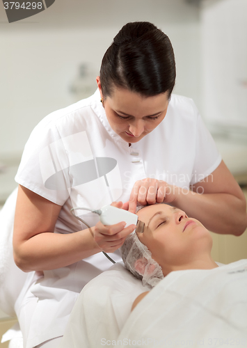 Image of Cosmetician providing ultrasonic facial cleaning