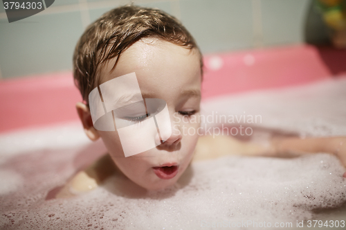 Image of Little boy enjoying a foamy bubble bath