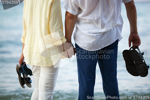 Image of Couple holding hands at the seaside