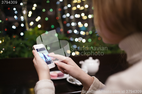 Image of Woman in cafe with phone