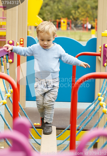 Image of Cute little boy playing in a playground