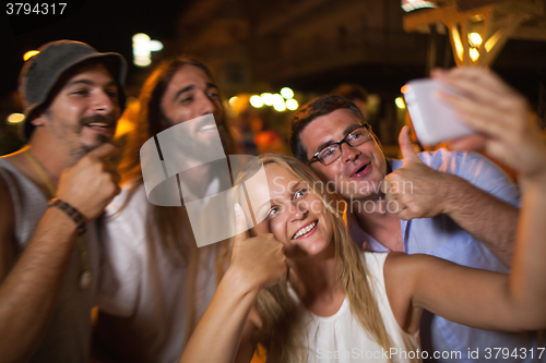 Image of Happy selfie of friends at night