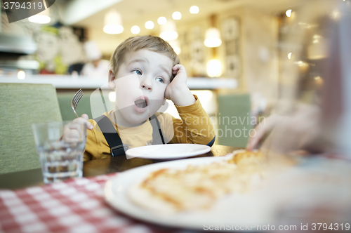 Image of Young boy yawning as he waits to be fed