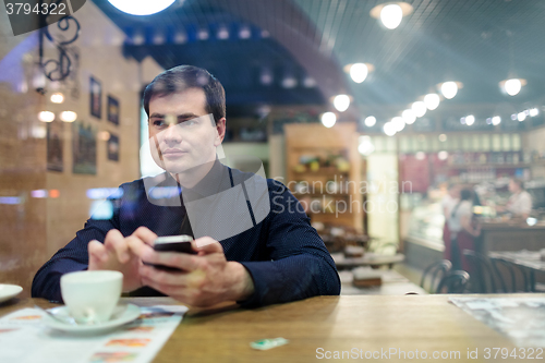 Image of Man at the table texting