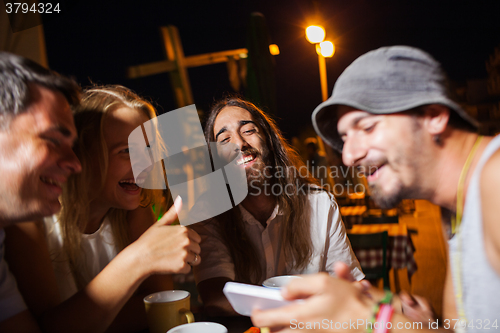 Image of Happy friends watching photos on the cell