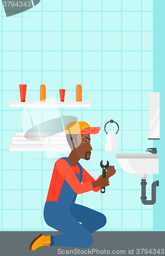 Image of Man repairing sink.