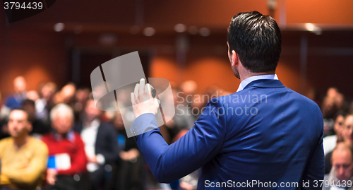 Image of Public speaker giving talk at Business Event.