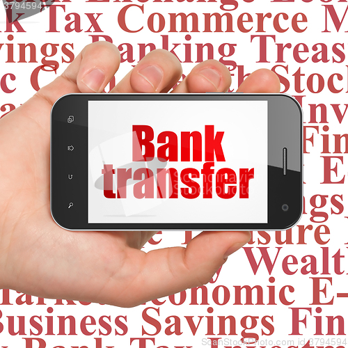Image of Money concept: Hand Holding Smartphone with Bank Transfer on display
