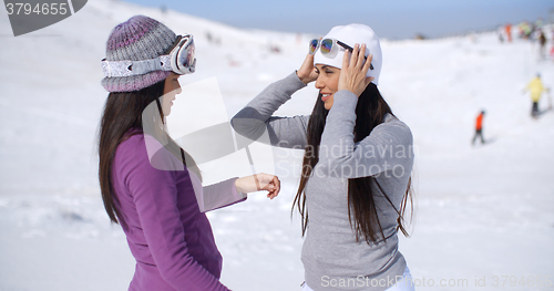 Image of Two stylish young woman chatting at a ski resort