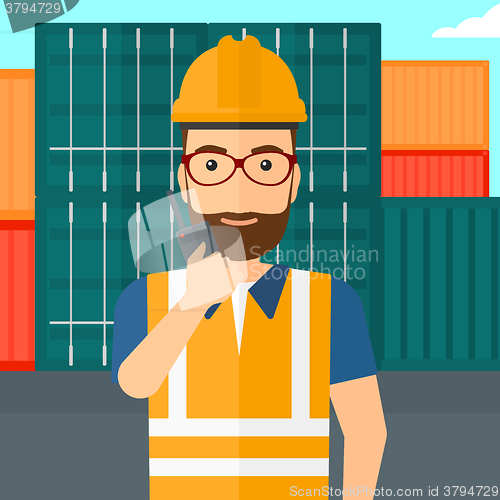 Image of Stevedore standing on cargo containers background.