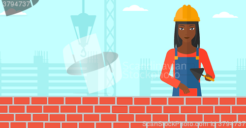 Image of Bricklayer with spatula and brick.