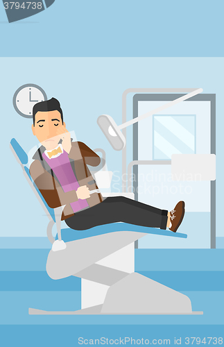 Image of Man suffering in dental chair.