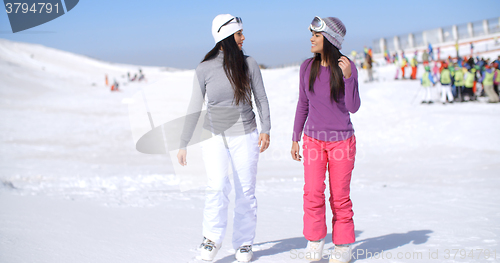 Image of Two attractive young woman walking in fresh snow