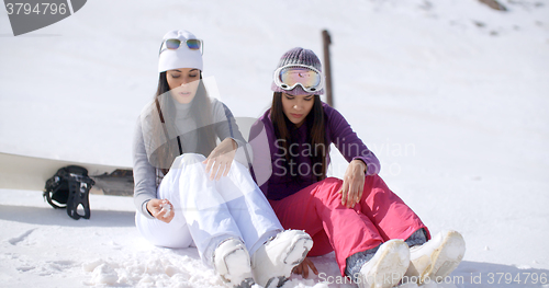 Image of Two young women sitting waiting in the snow